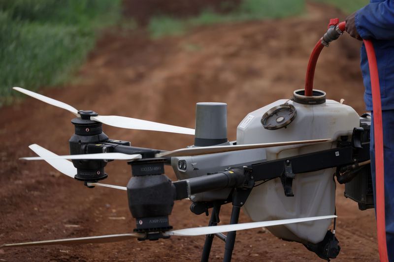 Close up of a spray drone tank being filled with a hose before a flight